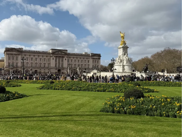 Buckingham Palace and the Victoria Memorial in London with visitors gathered outside after the Changing of the Guard