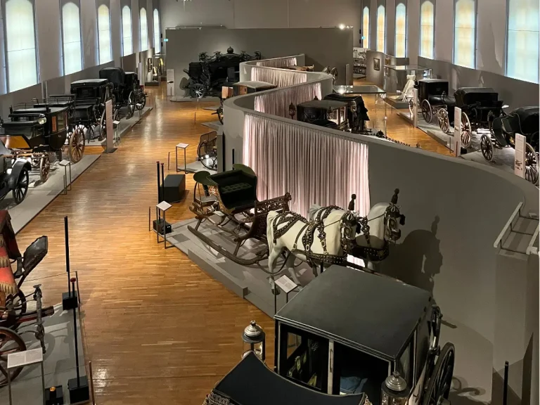 Interior of the Imperial Carriage Museum in Vienna showing historic royal carriages and exhibits inside the Schönbrunn Palace museum.