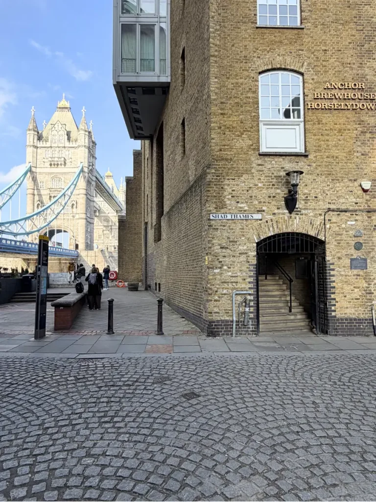 Shad Thames street near Tower Bridge in London with a view toward the bridge