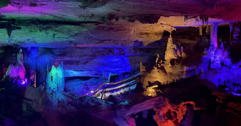 Colorful cave formations illuminated by multicolored lights during the Crystal Palace Tour at Raccoon Mountain Caverns in Chattanooga, Tennessee