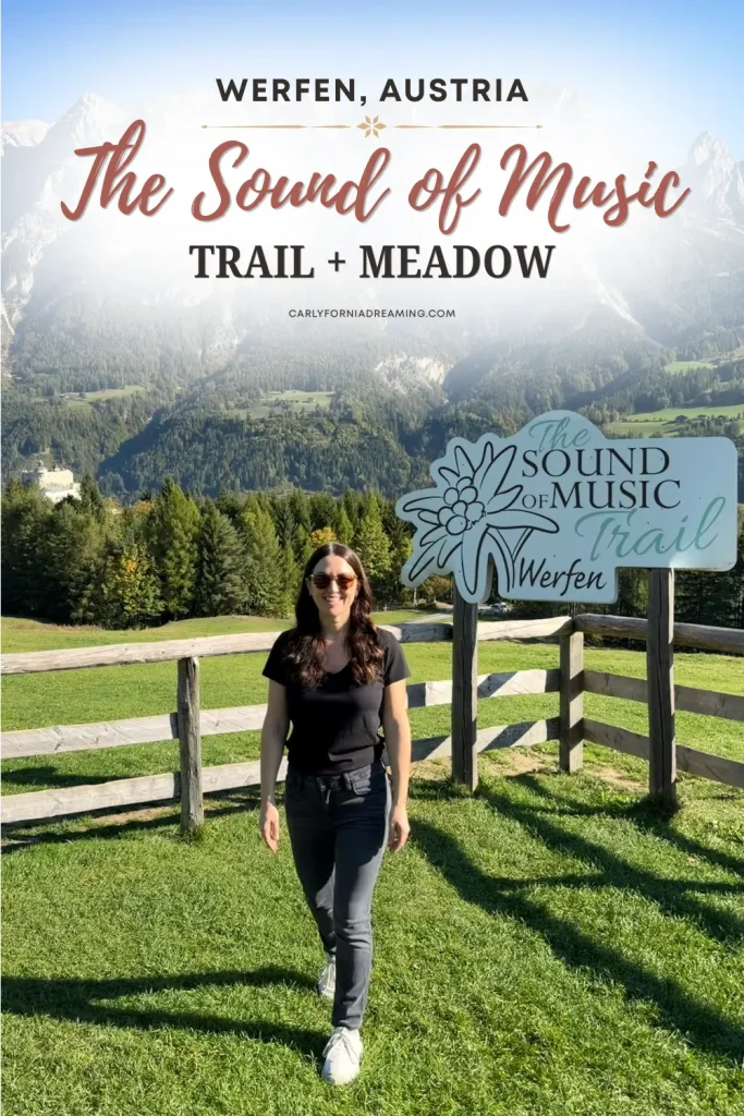 Pinterest pin featuring a woman standing beside the Sound of Music Trail sign at the famous Sound of Music Meadow in Werfen, Austria, with mountains in the background.